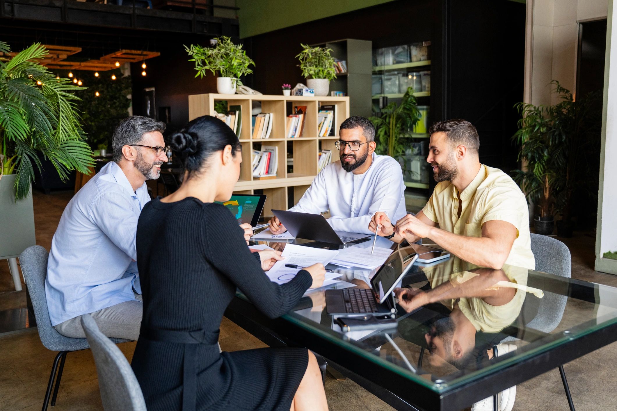 Small business team collaborating around laptops in a modern office.