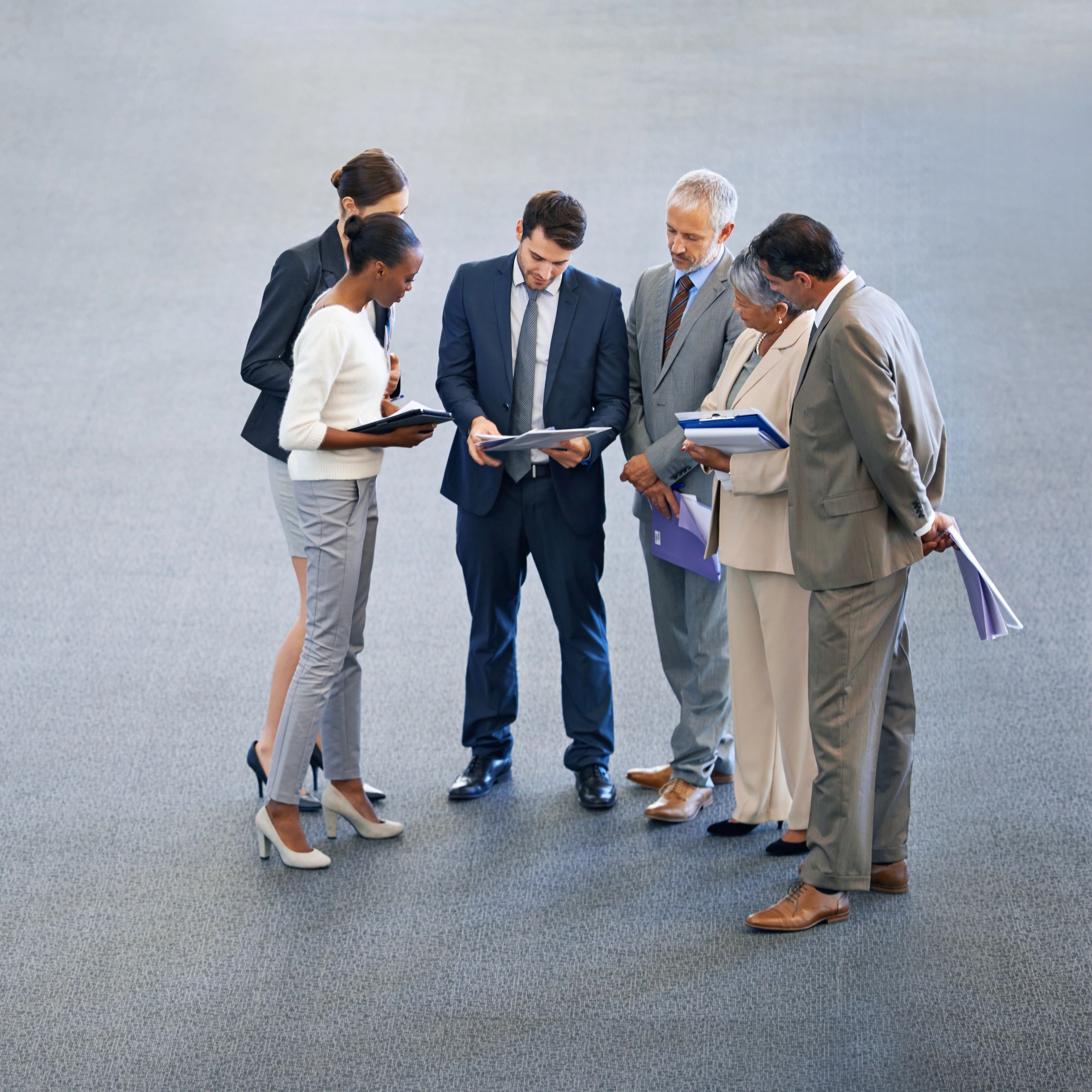 Team celebrating in an office meeting with documents in the air